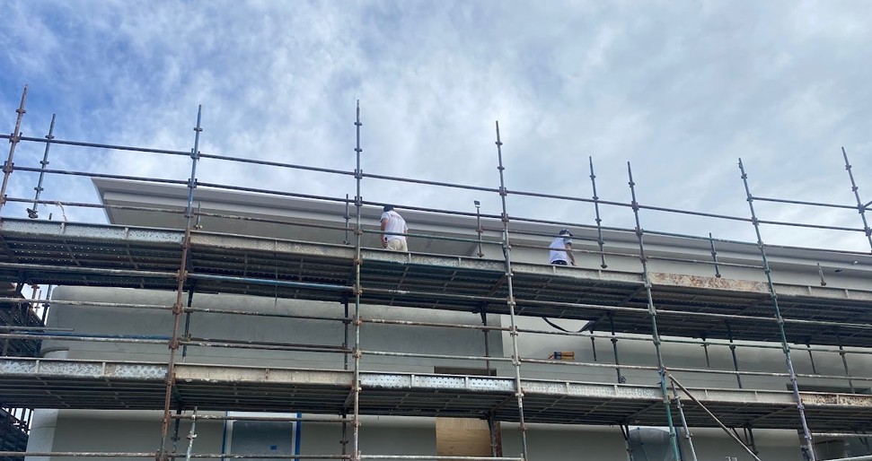 Painters on scaffold working on a new house build exterior