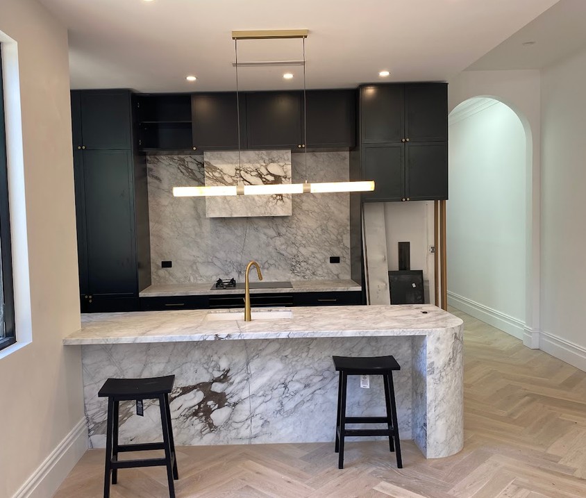 Dark feature kitchen with marble benchtops repainted in Annandale