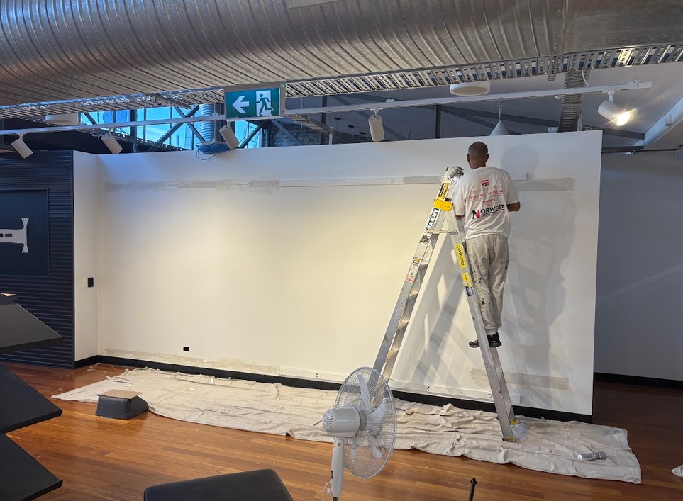 Painter finishing a wall in the Under Armour retail fitout
