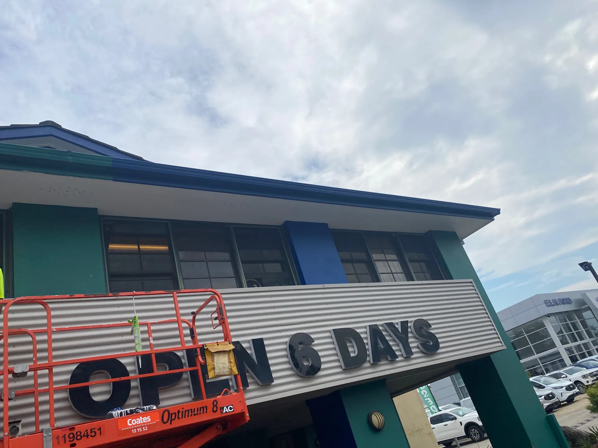 Exterior repaint in progress at Greencross Vets Tuggerah, with a scissor lift at the fascia